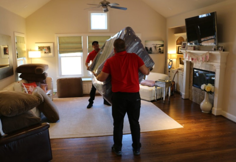 Movers moving couch out of living room in Hutto, TX