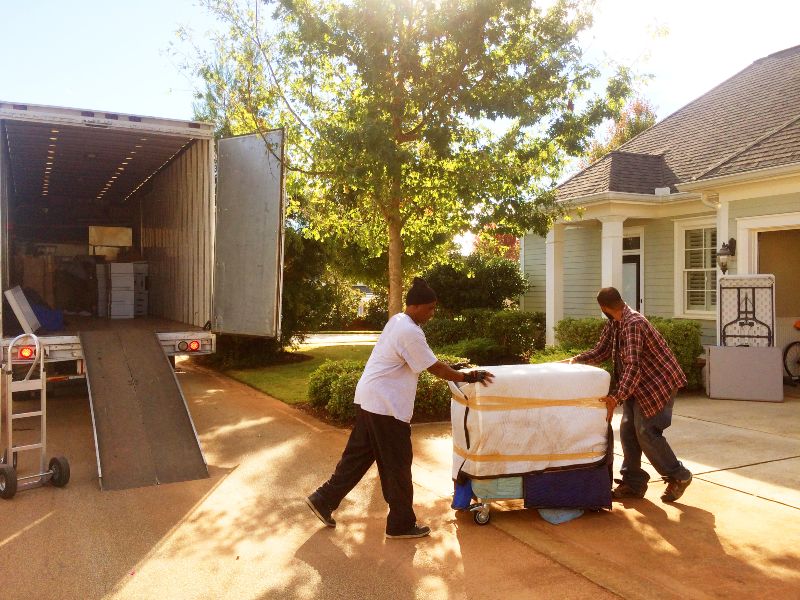 Two men unloading furniture from moving truck in Houston